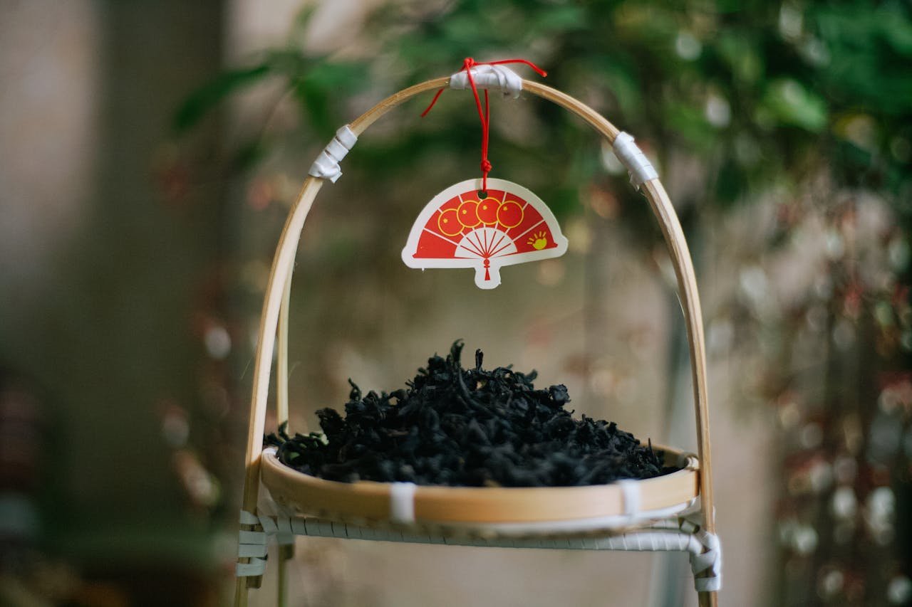 Aesthetic arrangement of dried tea leaves in a traditional bamboo basket, perfect for cultural and culinary themes.